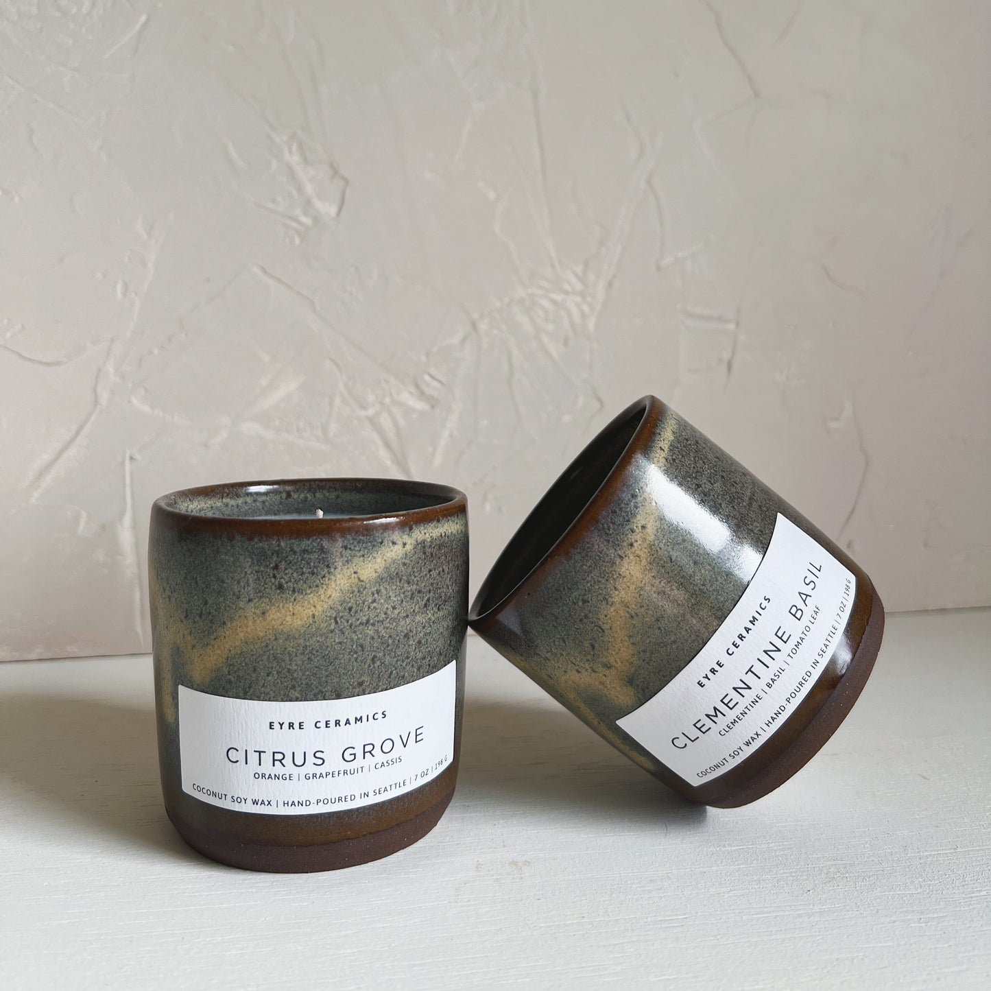 Two ceramic candles with labels on a light background