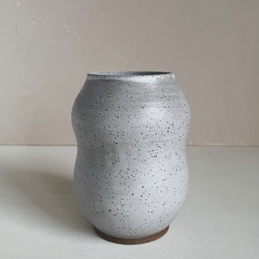 A handmade ceramic vase with a white satin matte glaze and speckled brown stoneware texture, displayed against a neutral background.