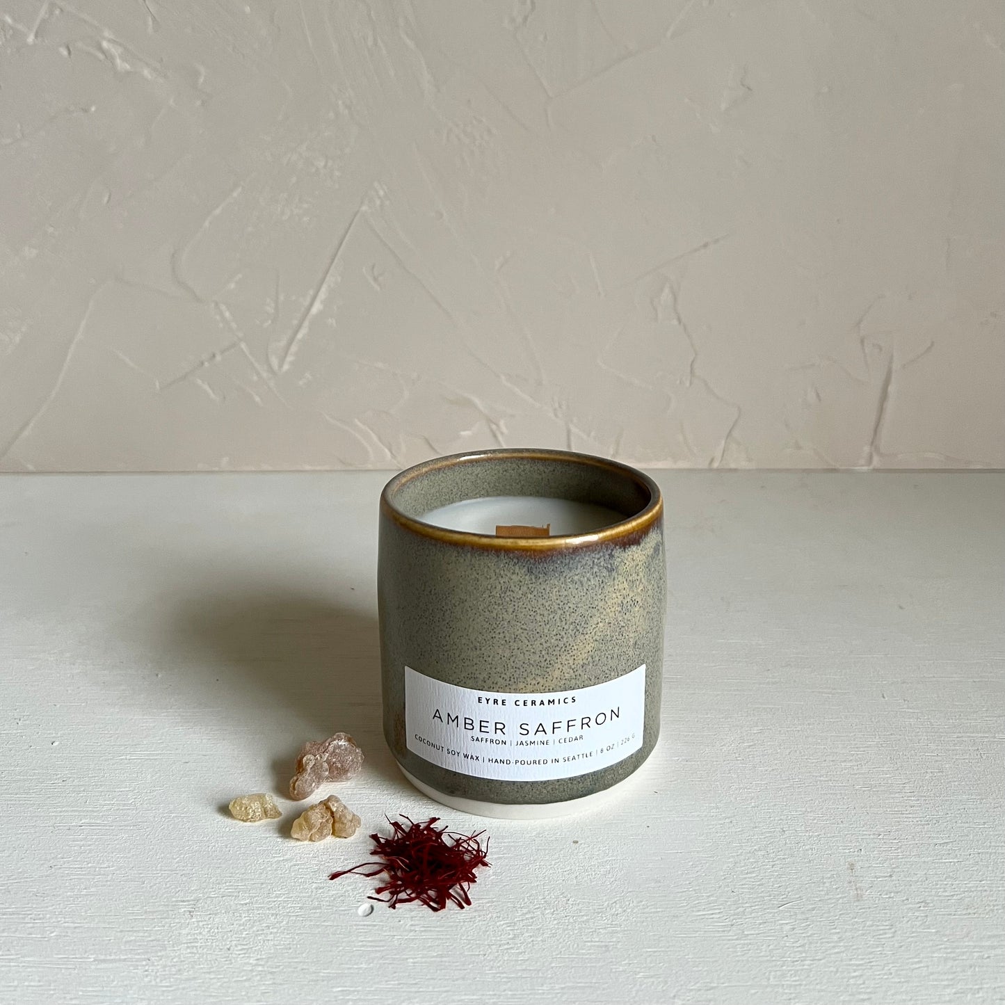 Ceramic candle with 'Amber Saffron' label on a neutral background
