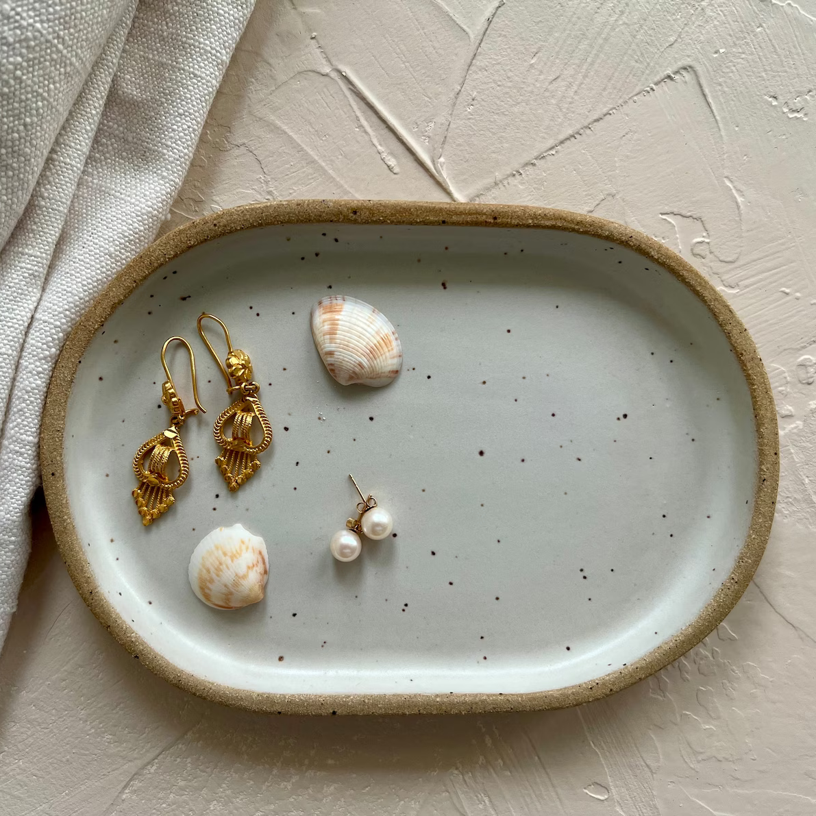 Handmade ceramic trays in various colors including Celadon, Rose, Shino, and Sky Blue, displayed on a surface.