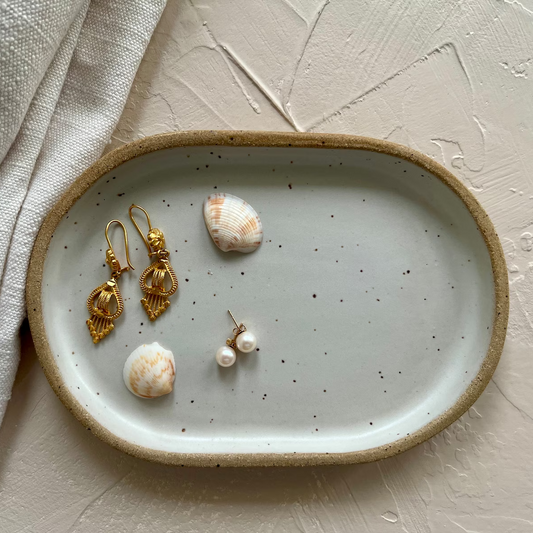 Handmade ceramic trays in various colors including Celadon, Rose, Shino, and Sky Blue, displayed on a surface.