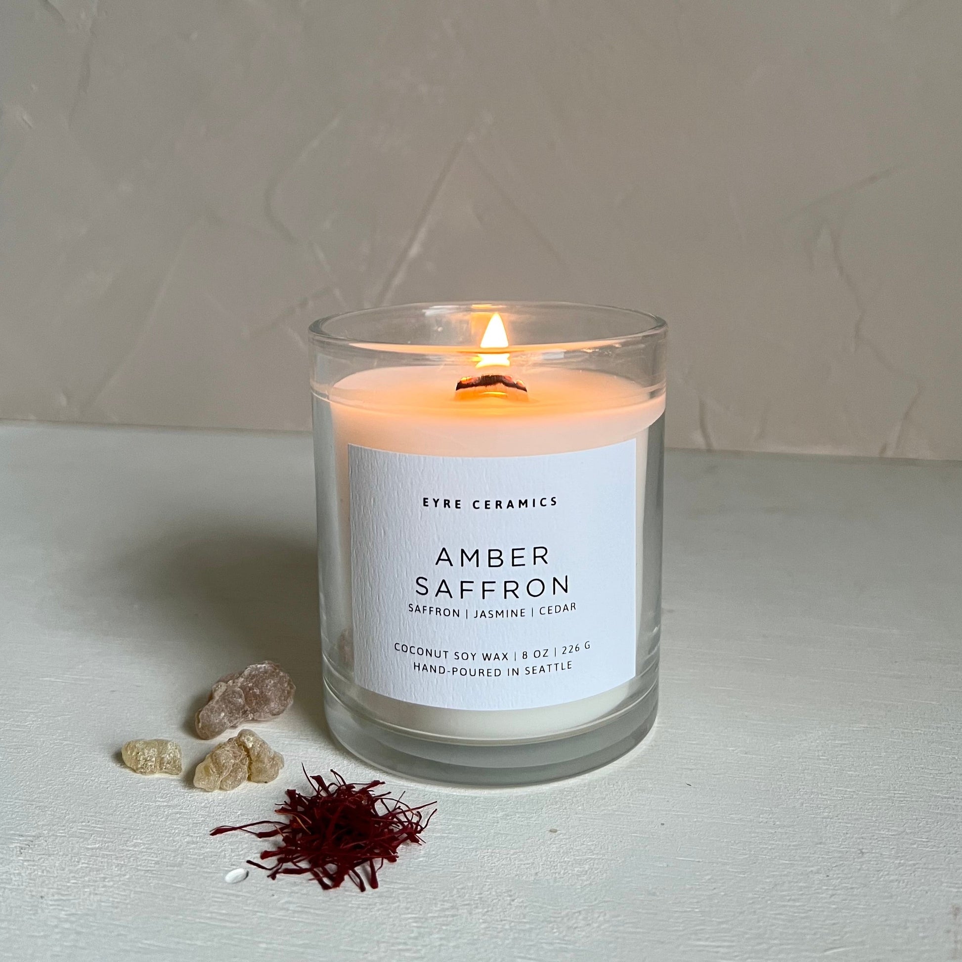 Candle labeled 'Amber Saffron' with a minimal background