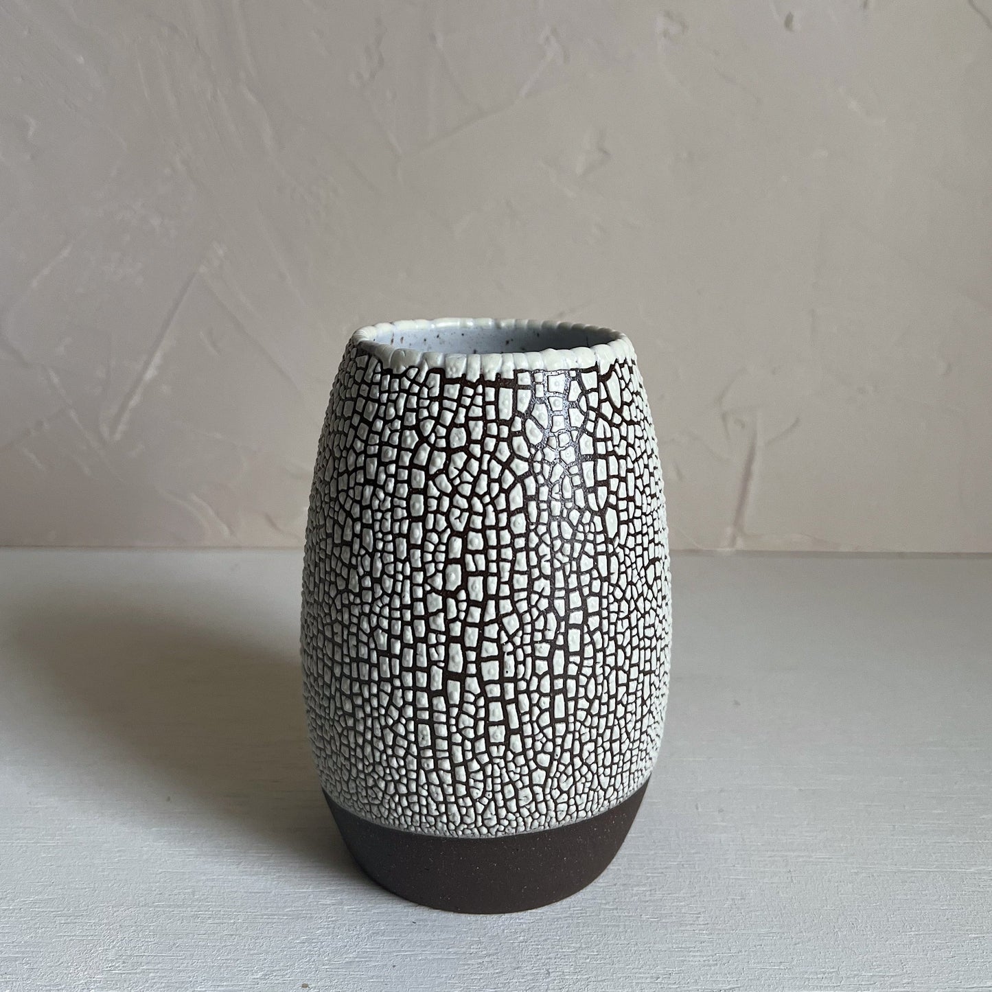 Ceramic vase with textured surface on a plain background